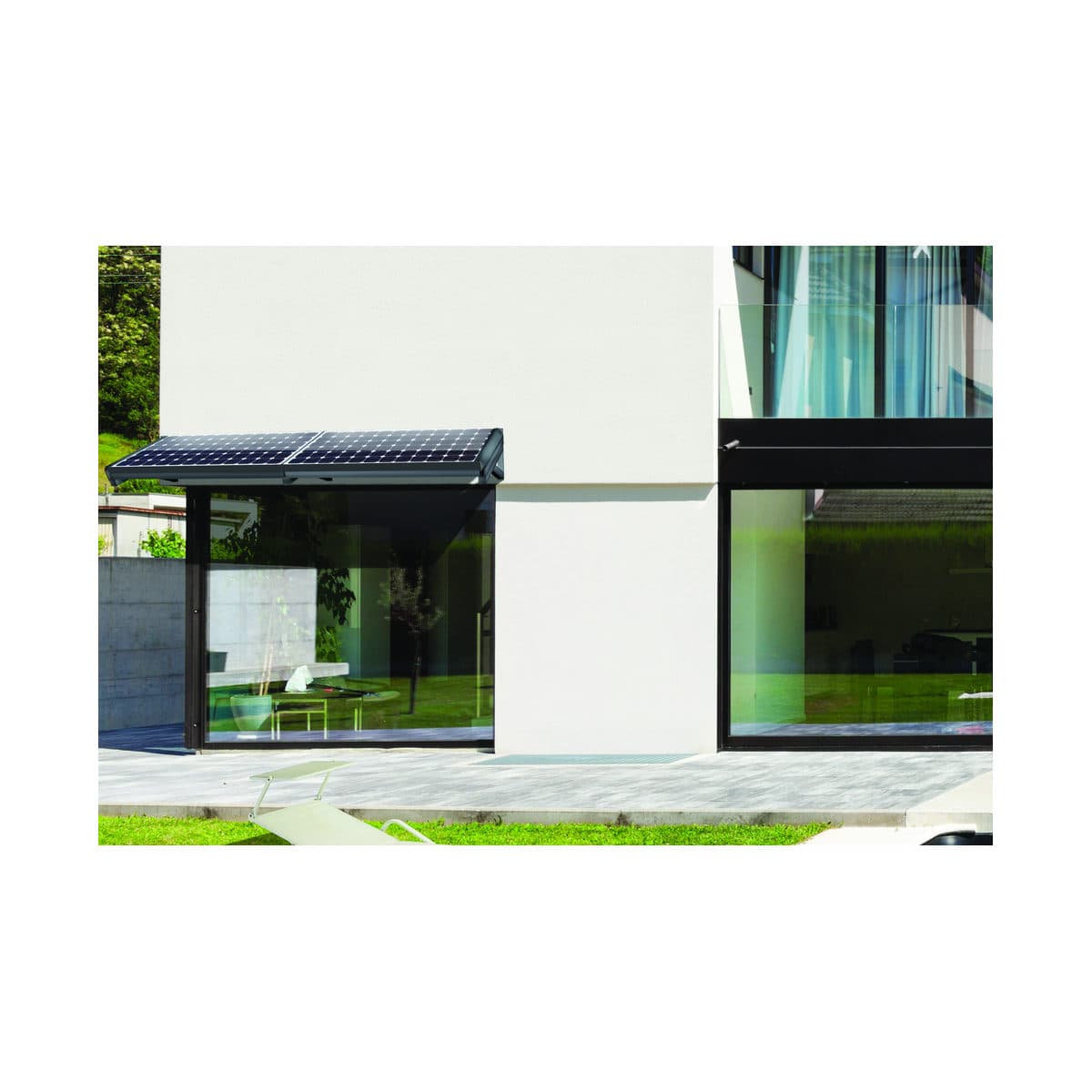 Brise-soleil Umbra Solar posé au-dessus d’une large baie vitrée, sur la façade blanche d’une maison contemporaine.